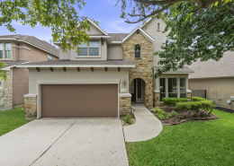 Two-story Austin home exterior with stone accents and arched entryway