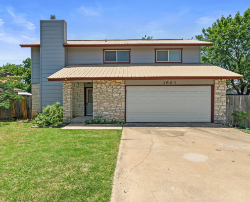 Two-story Round Rock home exterior with stone accents and driveway
