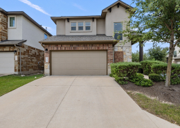 Stone-accented two-story home with landscaped driveway in Cedar Park