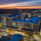 Bloomfield apartment building with ground-floor retail at sunset